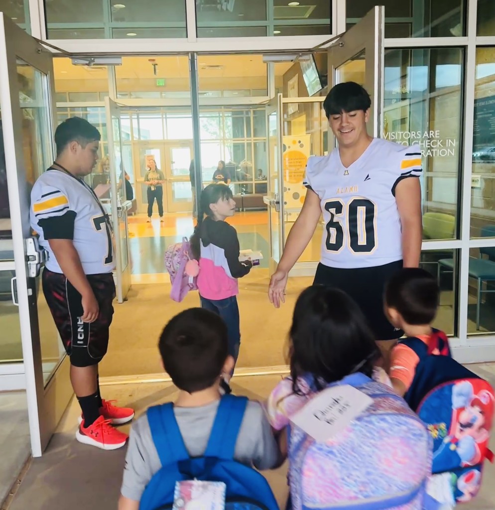 Alamogordo Tigers Football Team giving high fives to Desert Star kids.