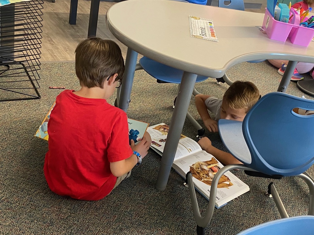 children under desks reading for enjoyment