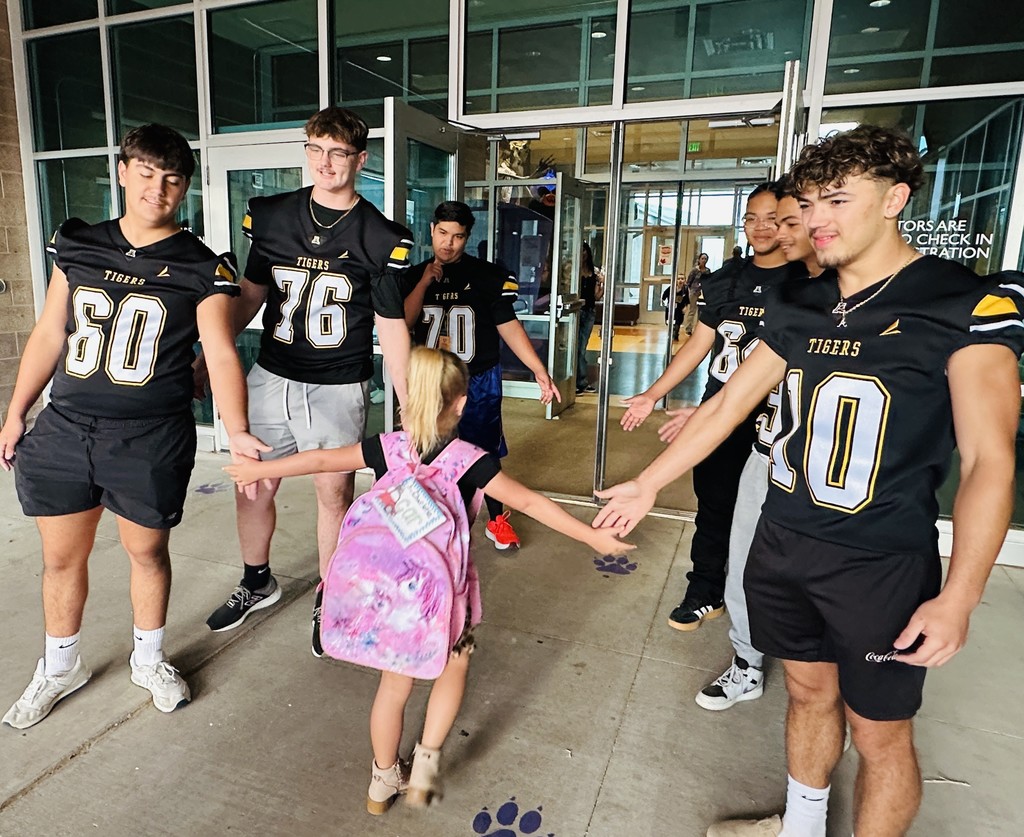 Desert Star Student giving fives to the AHS Tigers