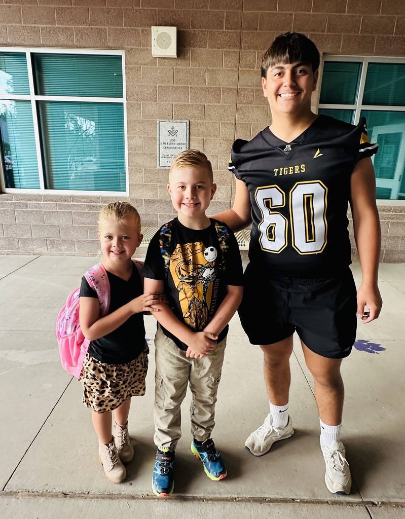 Desert Star students with a AHS Tiger football player.