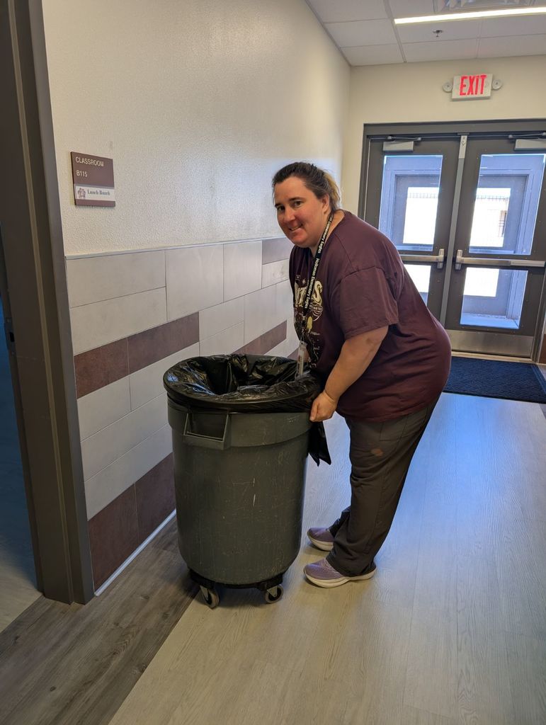 custodian puttin a bag over a bin