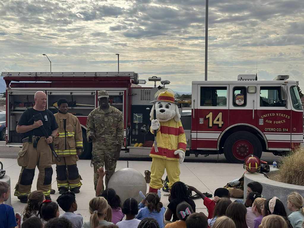 Sparky showing students tools that firefighters use during an emergency