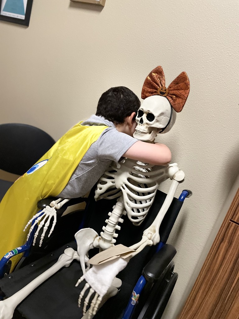 Student hugging skeleton.
