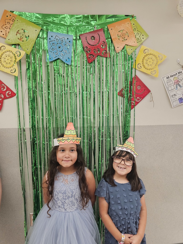 Two female students wearing hats they decorated