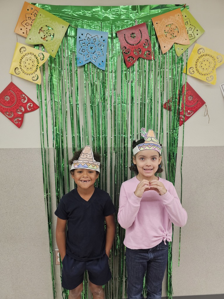 two students smiling in front of green streamers
