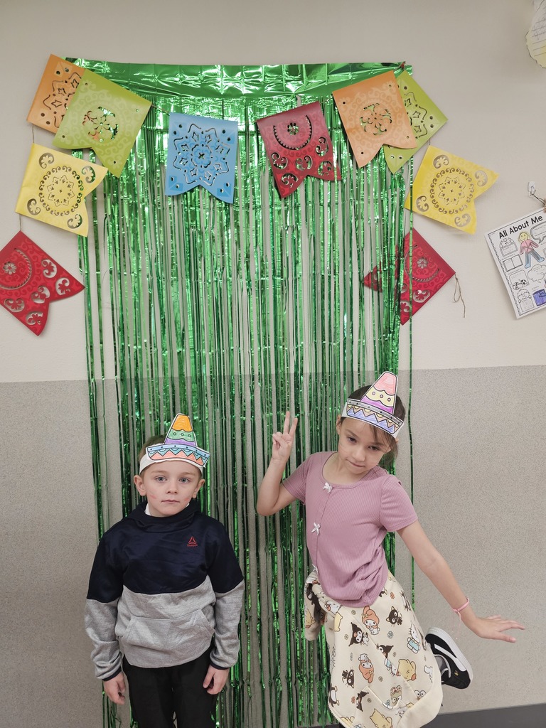 two students standing in front of green streamers