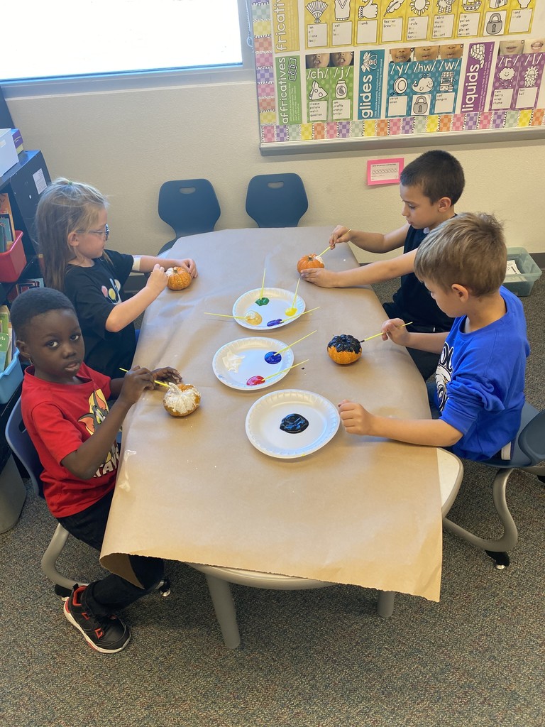 students painting pumpkin
