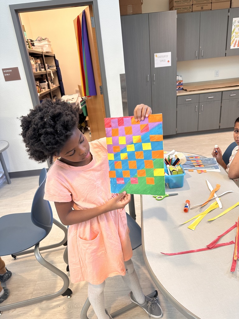 student holding art work