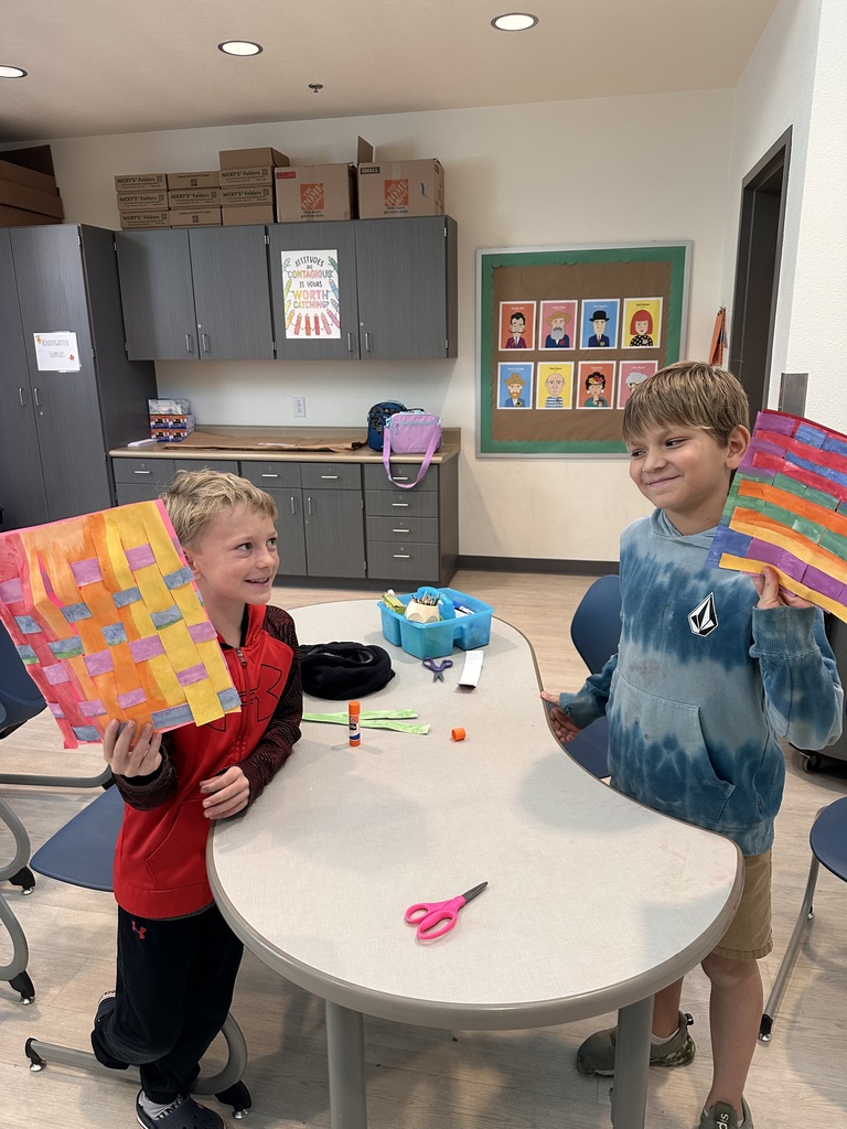 student sharing their artwork with classmates