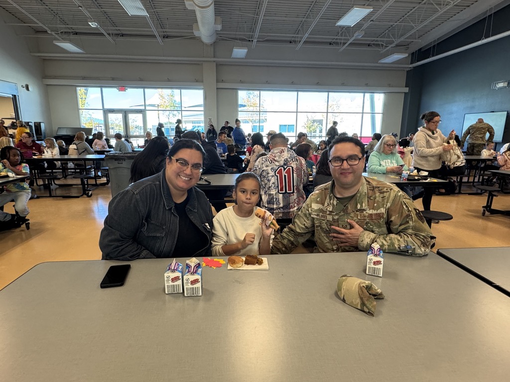 Second grade child eating with their parents