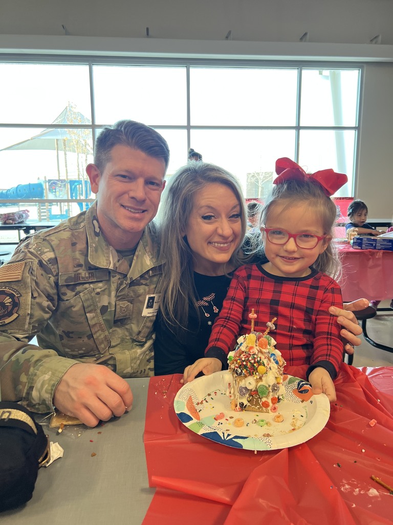 family showing off gingerbread build