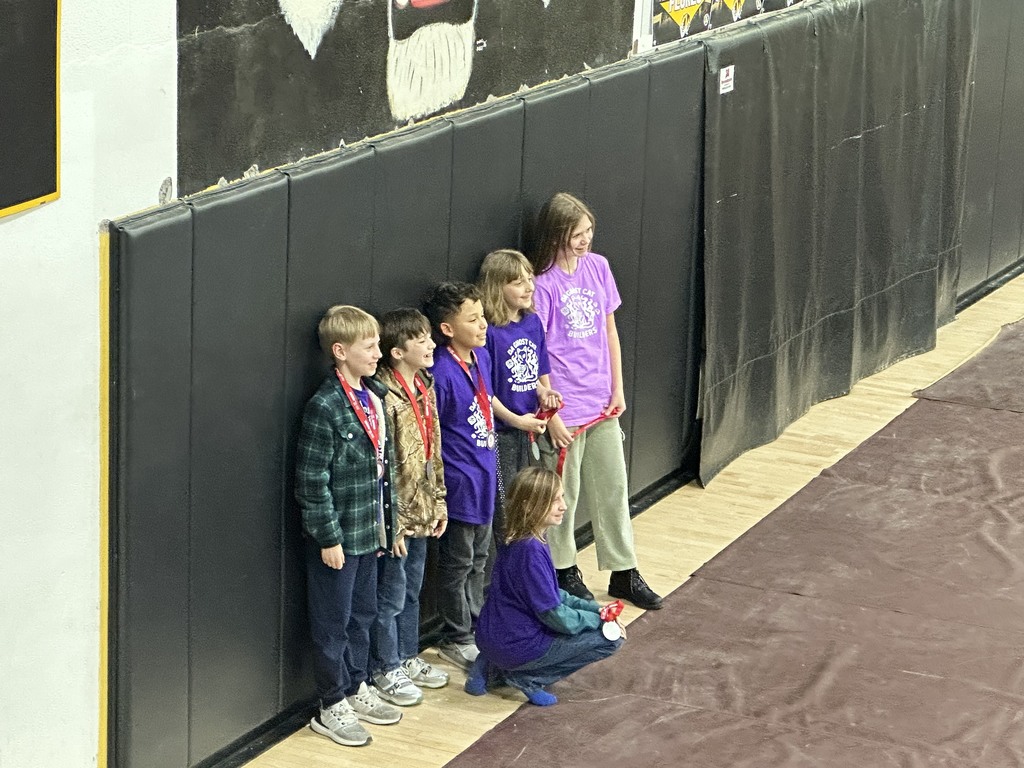 Students standing against a padded wall