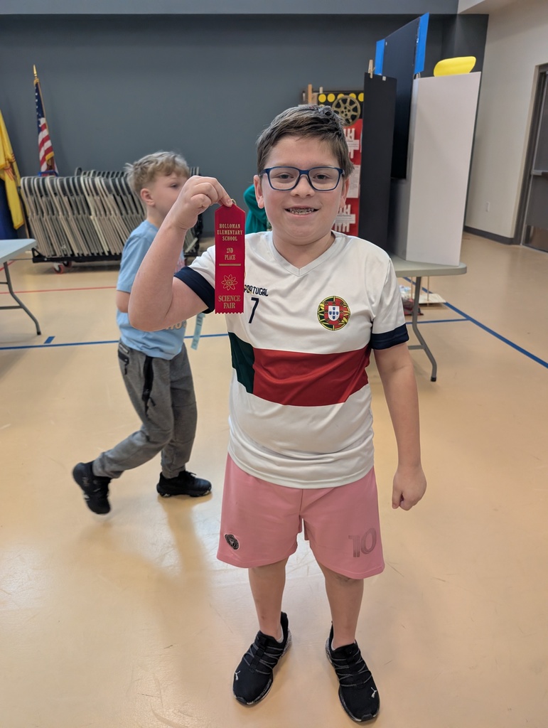 student showing off their science fair ribbon prize