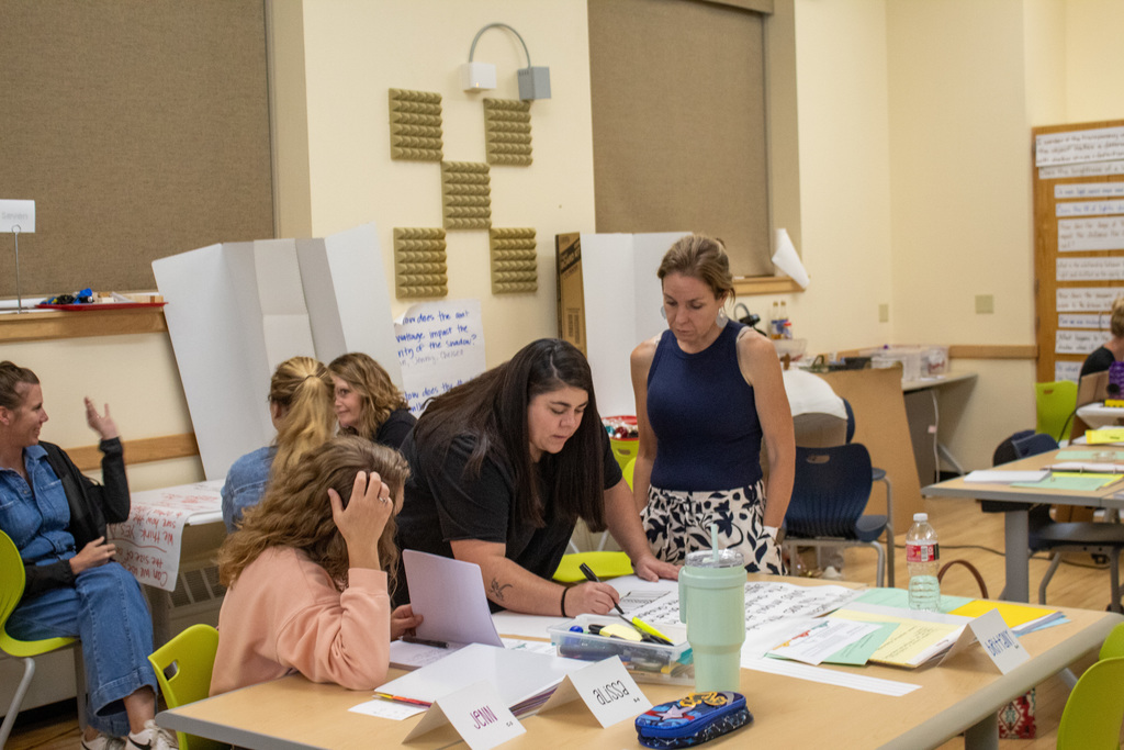 ACSD#1 teachers gathered around a table writing on poster