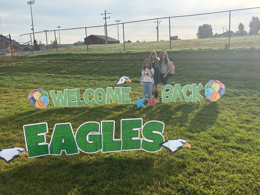 Slade students posing behind welcome back sign