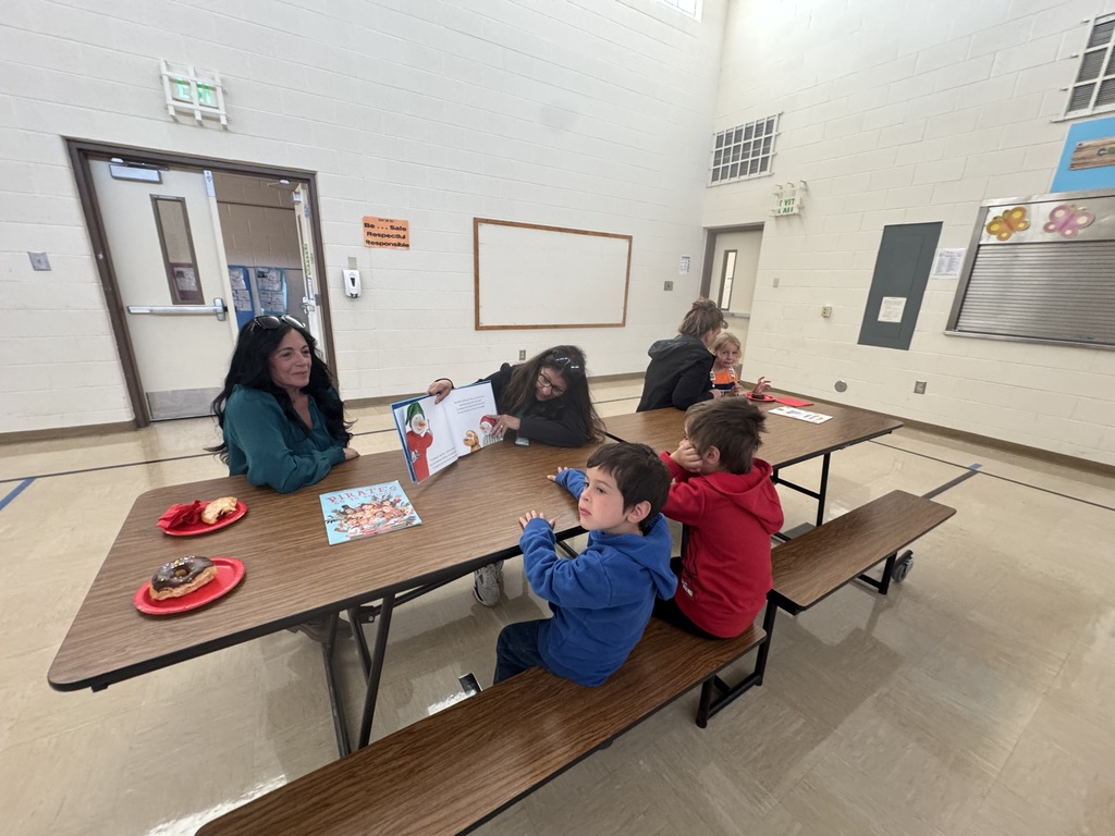 Students eating breakfast with family with reading