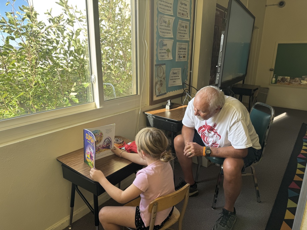 Student reading grandpa at a school desk