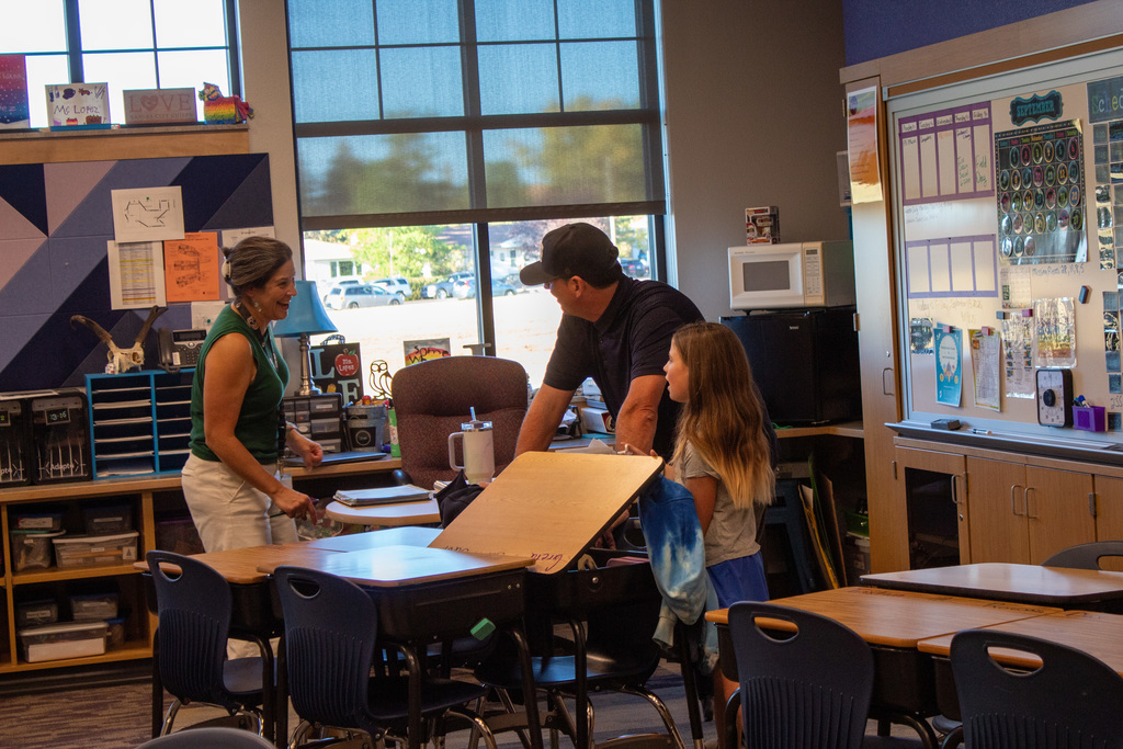 Student and parent visiting with classroom teacher