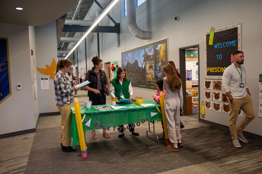 students and parents visiting with school staff 