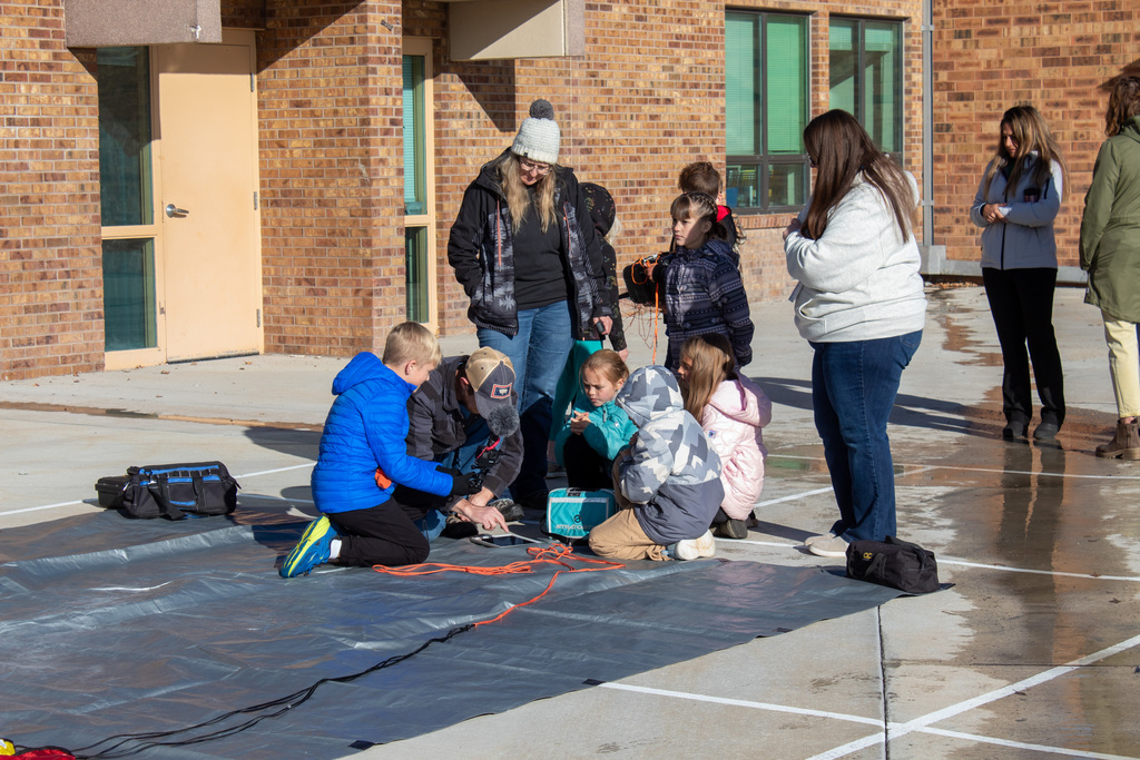 Students helping attach payload to the weather balloon