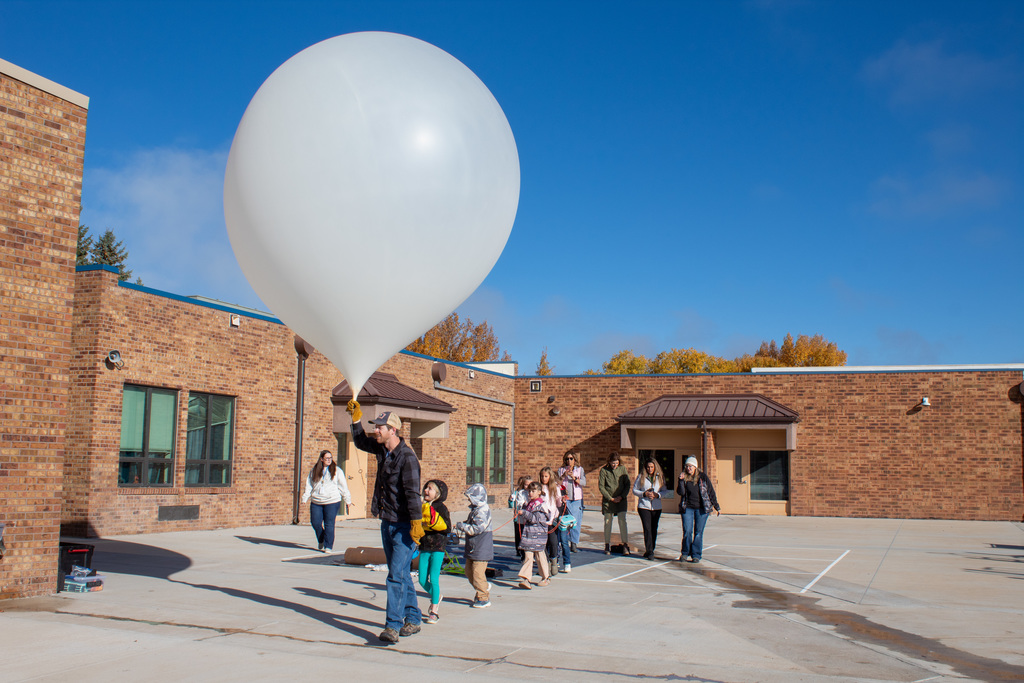 Students and UW staff carrying weather balloon to the launch site