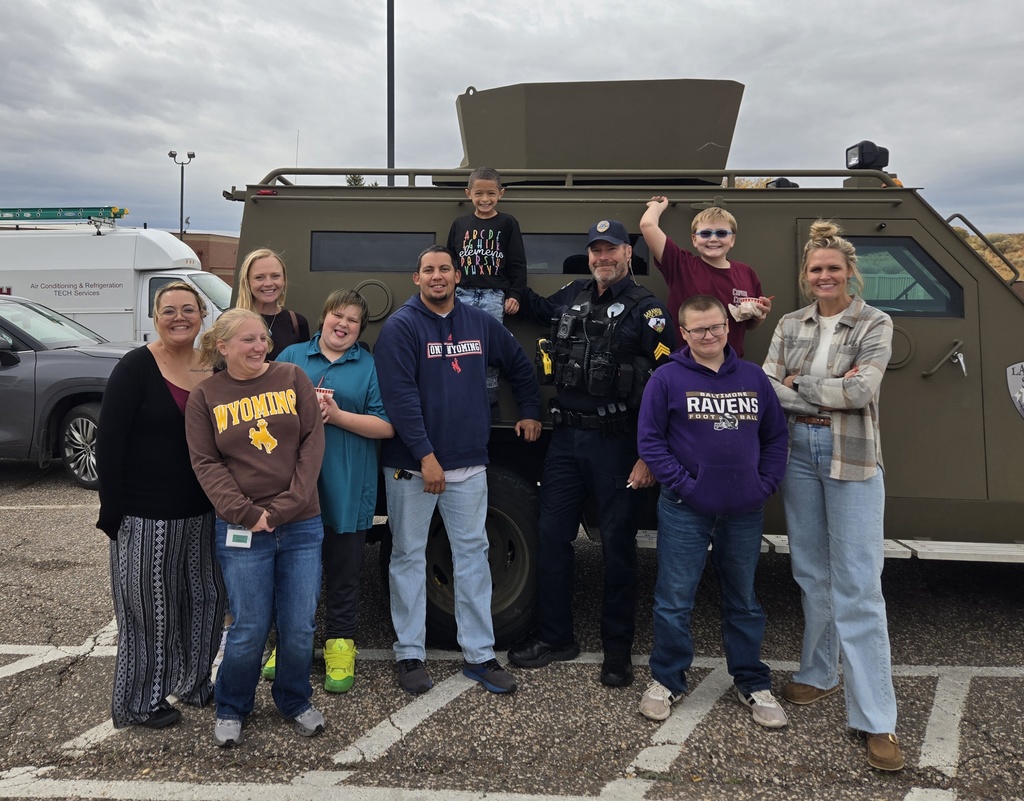 Students posing outside of armor vehicle