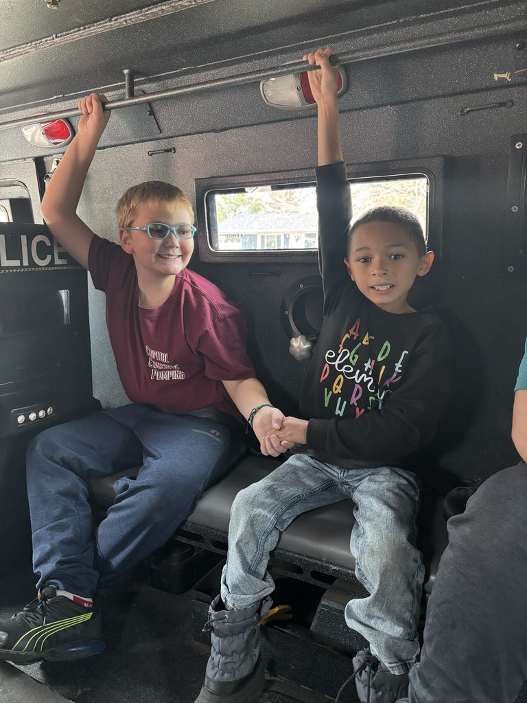 Students riding in police autmobile