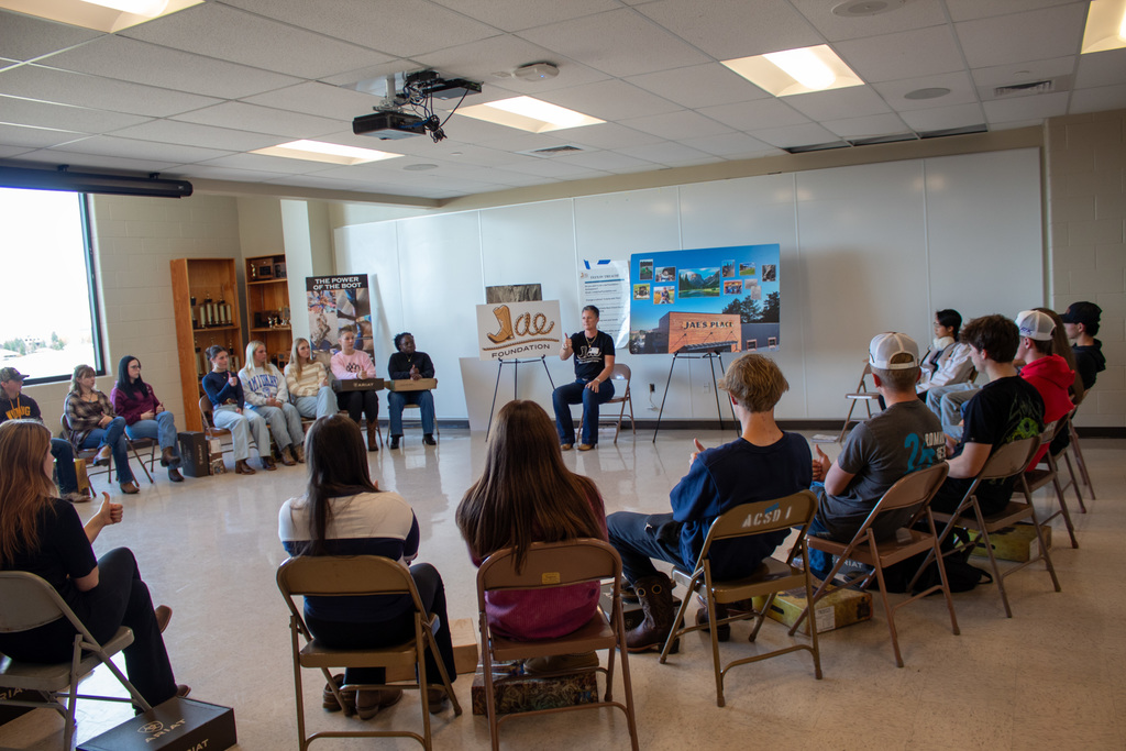 Students sitting in a circle listening to the Jae foundation presentation