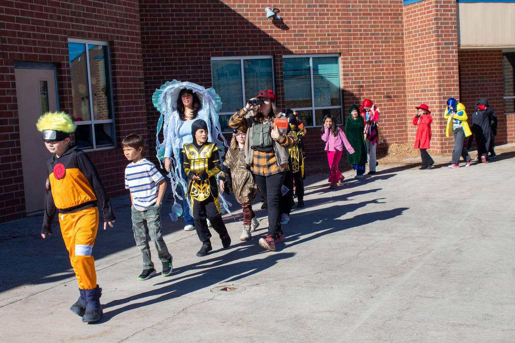 Students dressed up for Halloween, walking in the school Halloween parade