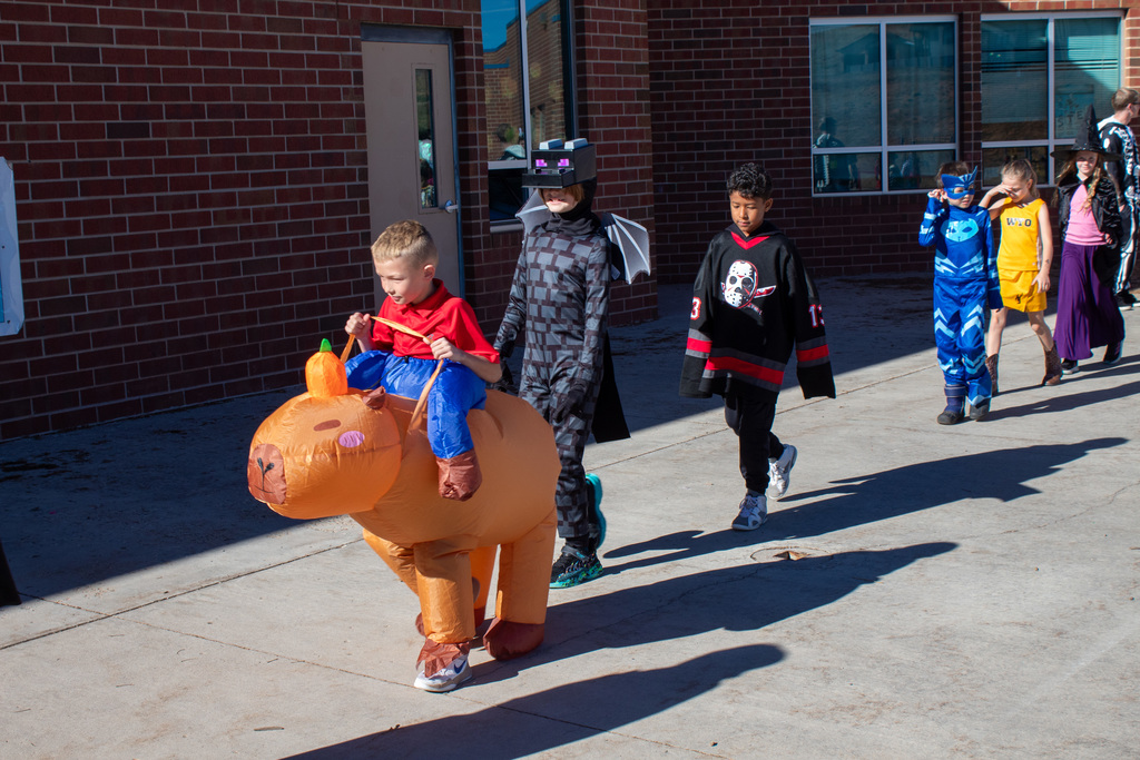Students dressed up for Halloween, walking in the school Halloween parade
