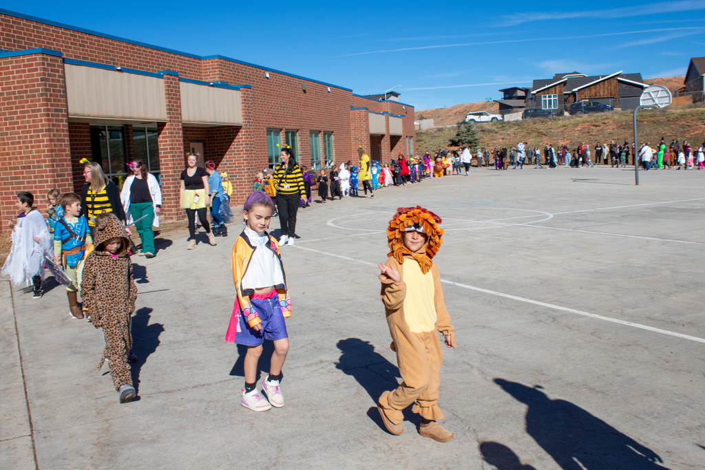 Students dressed up for Halloween, walking in the school Halloween parade