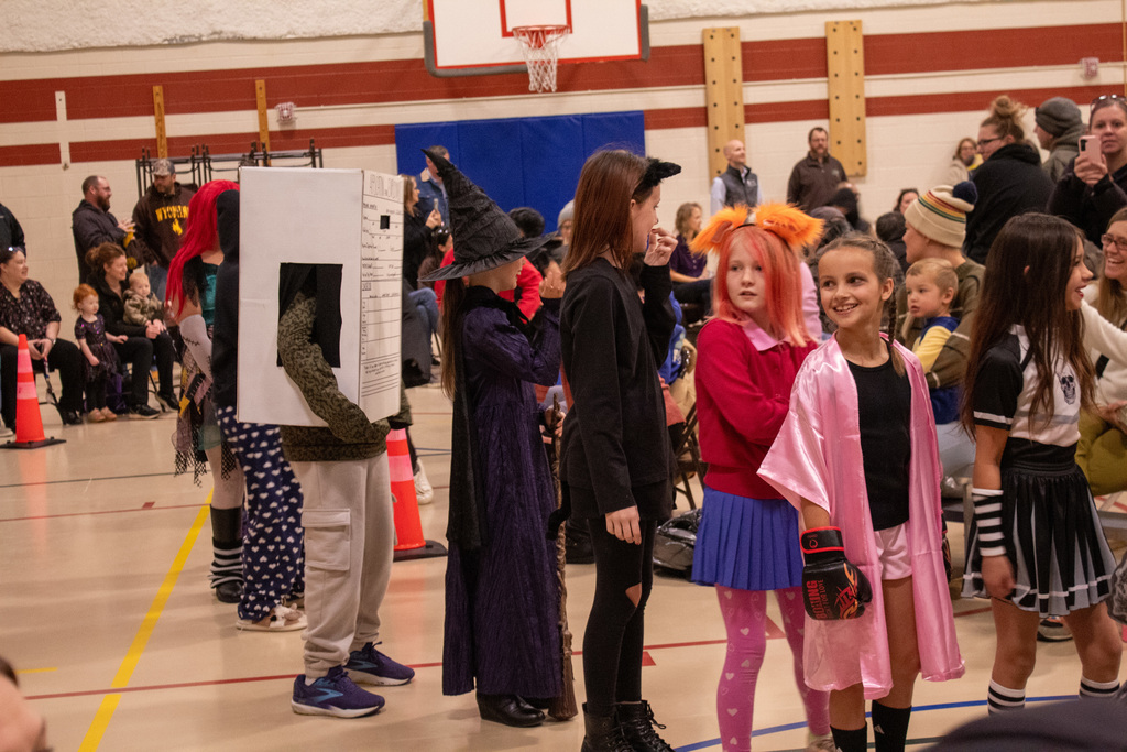 Students dressed up for Halloween, walking in the school Halloween parade