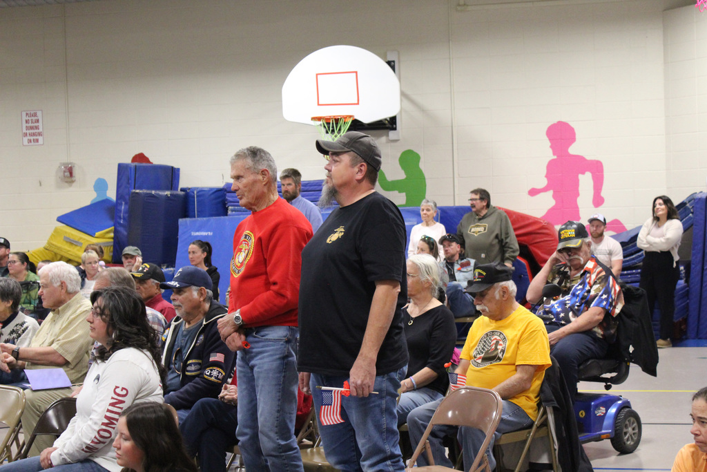 Veterans standing to be recognzied at Linford assembly