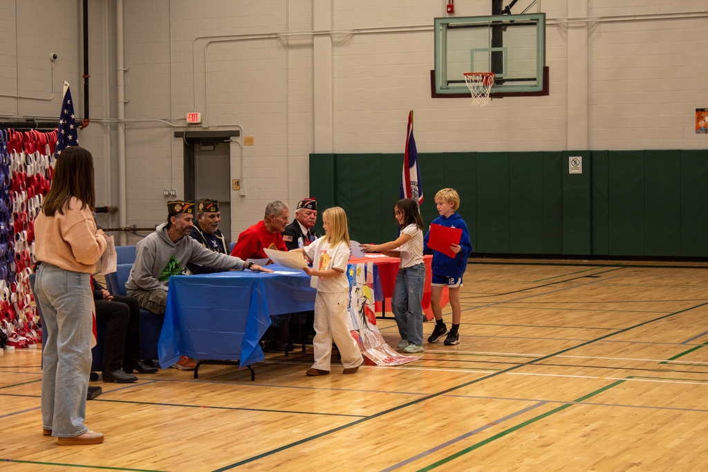 Students handing veterans artwork