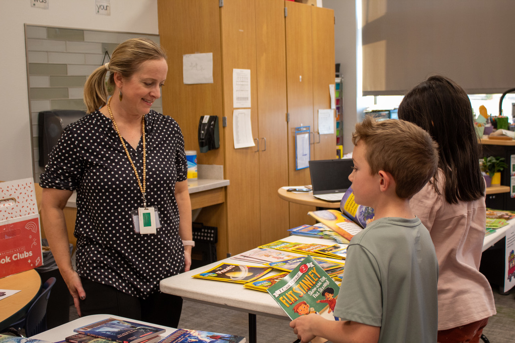 Students and teachers looking at  books