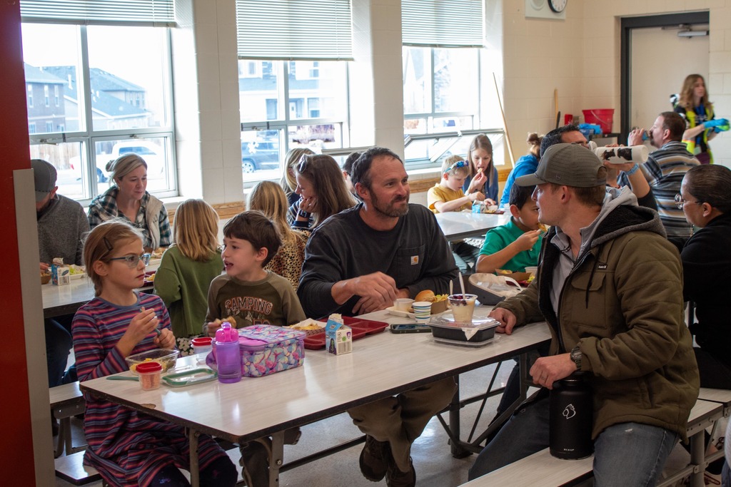 Students eating holiday lunch with parents