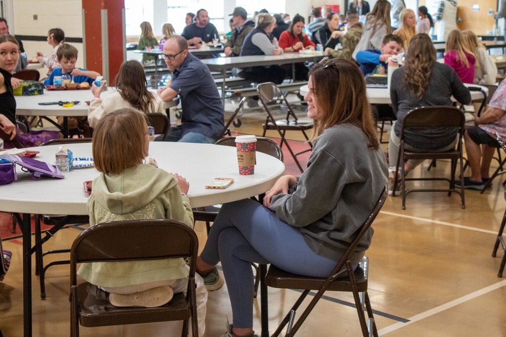 Students eating holiday lunch with parents