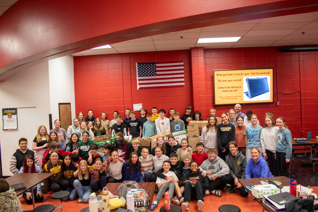 8th graders gathered around donation food items