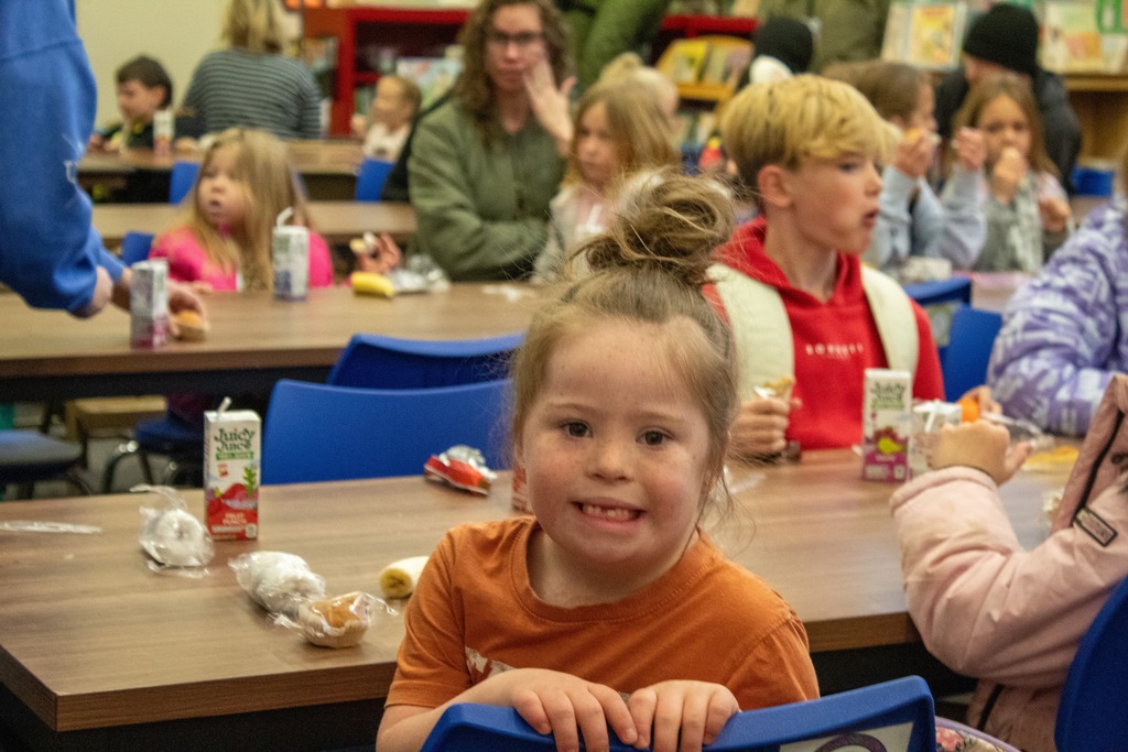 student smiling for the camera while sitting at a table