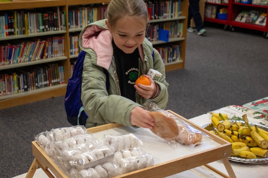 Child grabbin breakfast from a table