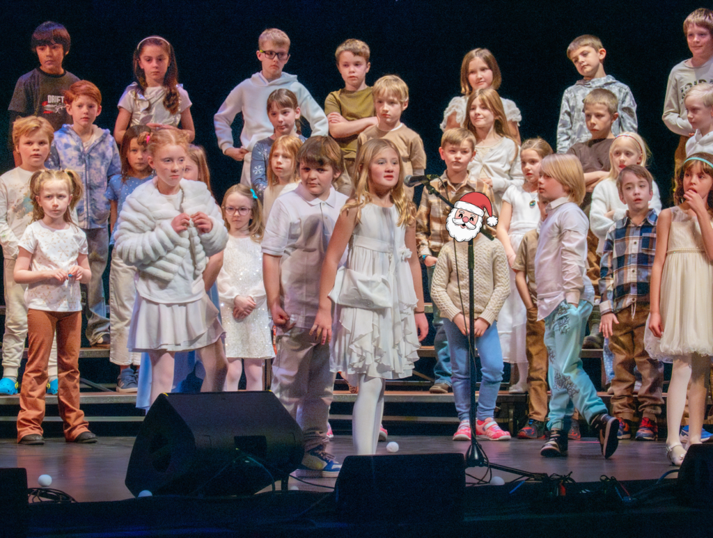 Student singing into microphone while classmates stand behind