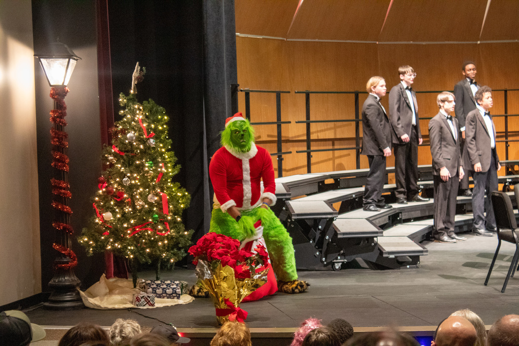 Student singing while the grinch runs around the stage