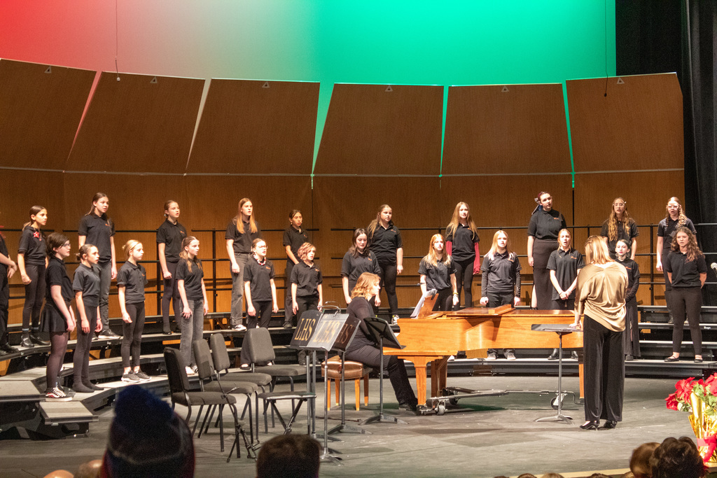 Students in choir singing on stage