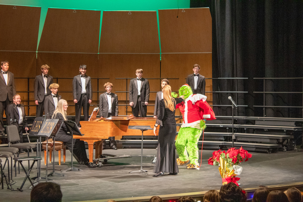 Student singing while the grinch runs around the stage