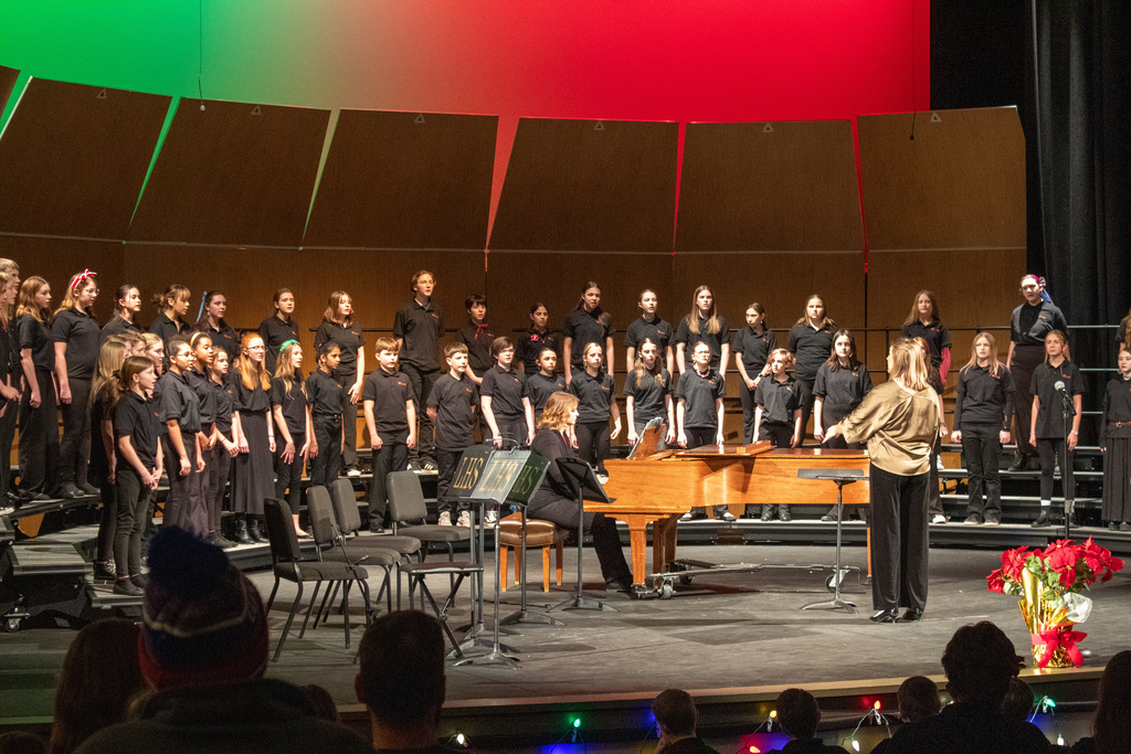 Students in choir singing on stage