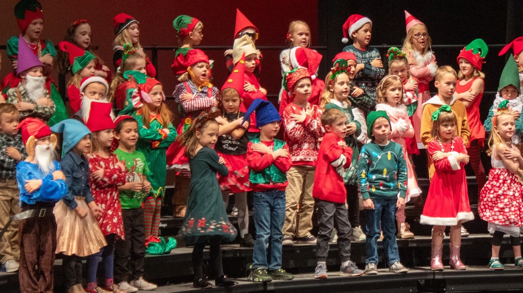 students standing behind cardboard sleigh dressed as gnomes