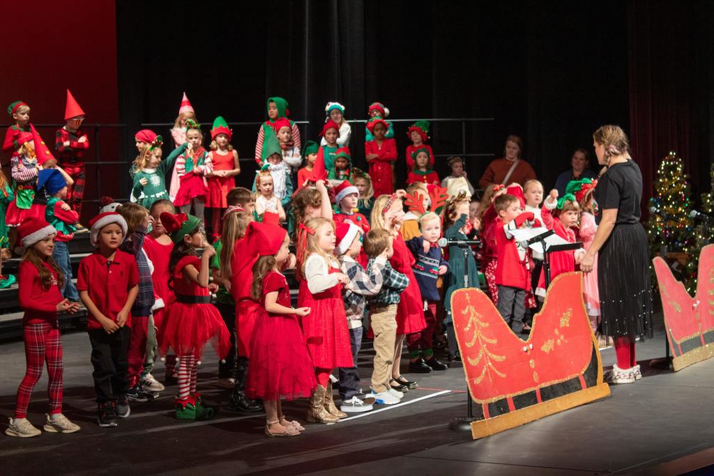 students standing behind cardboard sleigh dressed as gnomes