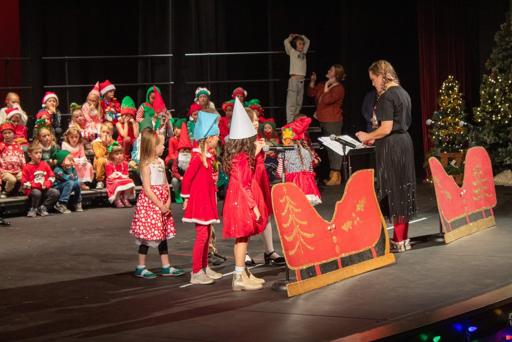 students standing behind cardboard sleigh dressed as gnomes