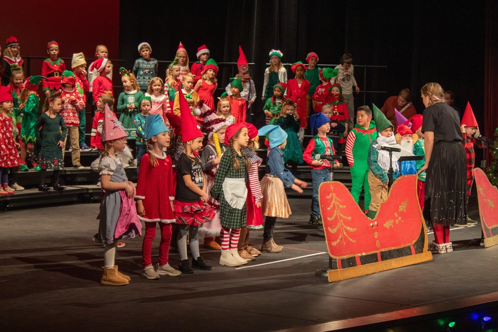 students standing behind cardboard sleigh dressed as gnomes
