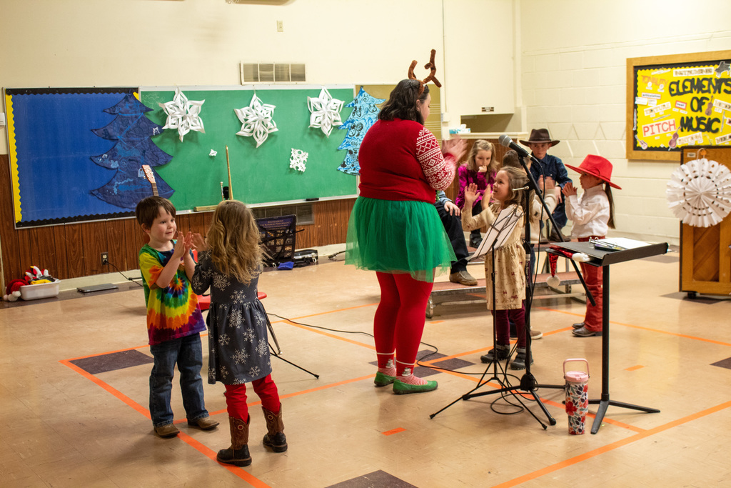children dancing in the gym with teacher